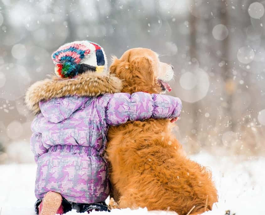 Kind mit Hund im Schnee